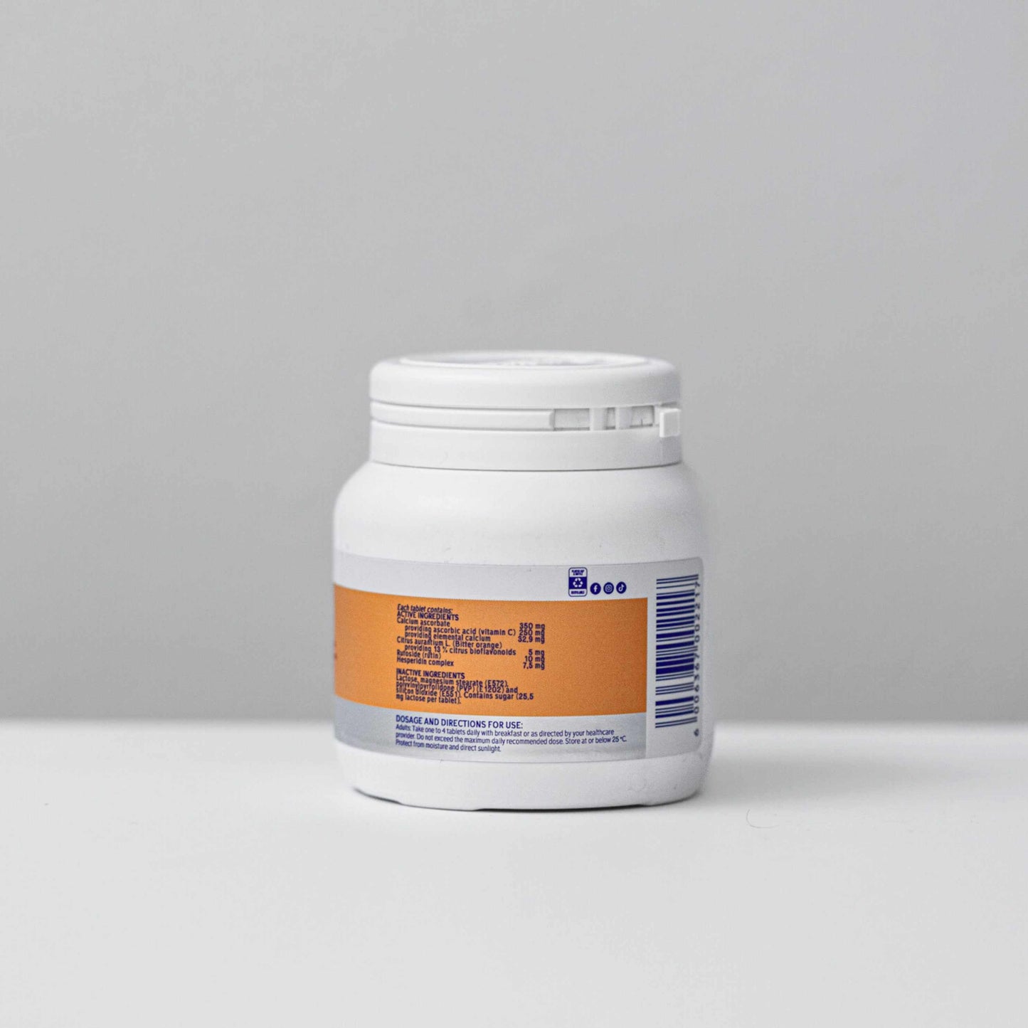 White bottle of Non-Acidic Vitamin C 250mg tablets with orange label on gray background